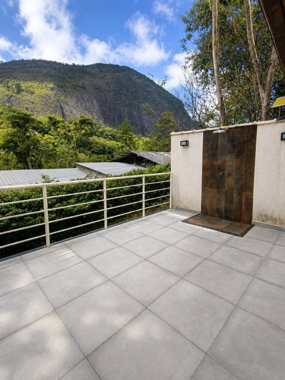 Varanda com chuveirão e vista da montanha